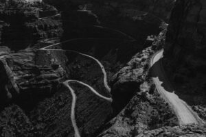 A road with tight switchbacks winds up a mountain beneath you. Driving that would probably give you vertigo, and walking it would probably give you blisters. Luckily, you're a camera drone.