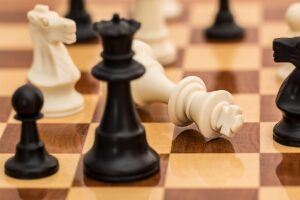 A chess queen stands disdainfully before the fallen king-piece at her feet. The game is won, but her reign has only just begun.